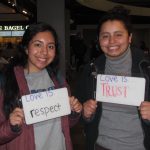 Students holding signs that say “love is respect and “love is trust”