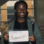 Student holding a sign that says “love is respect”
